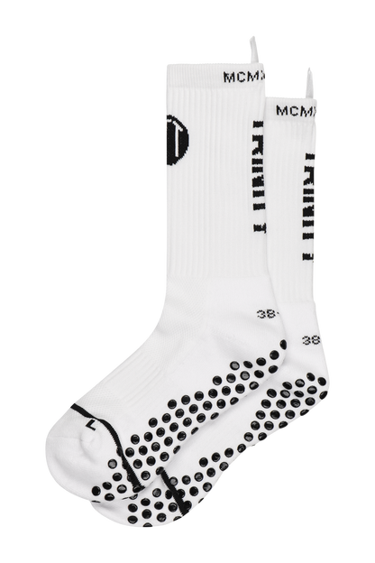 White anti-slip grip socks by TRINITY, featuring a sleek design with dotted grip patterns for enhanced stability and comfort, perfect for various sports like running, football, padel, pilates and gym workouts.